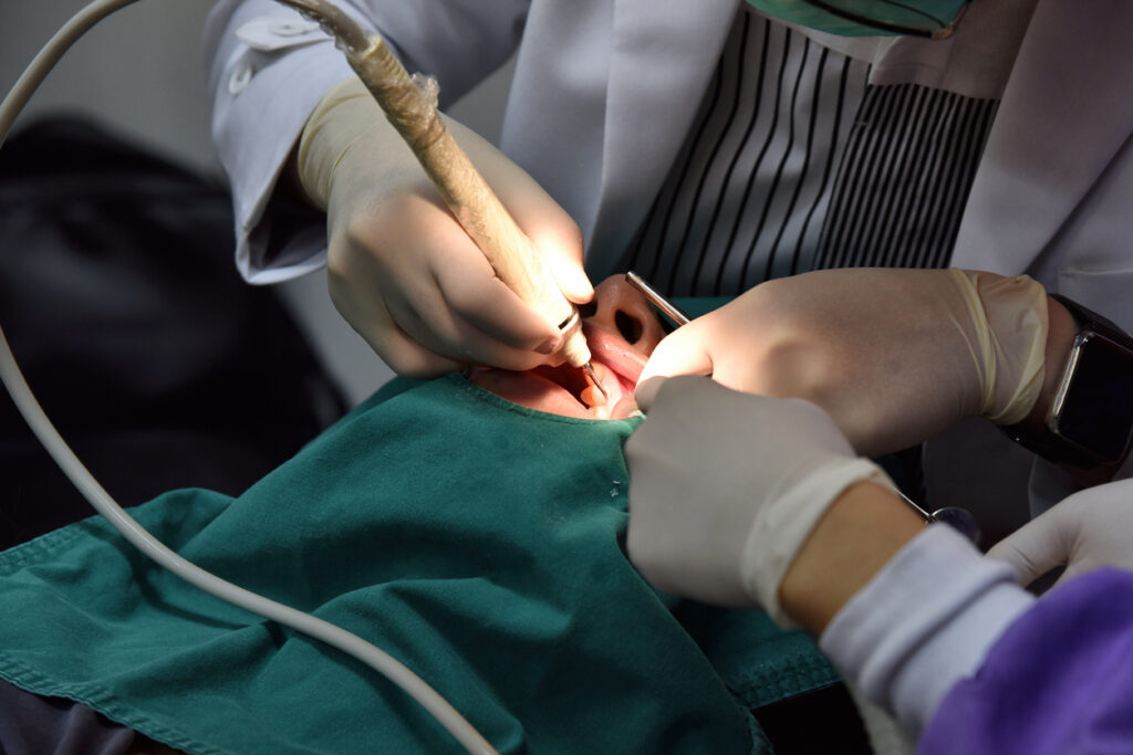 Dentist examining and doing teeth treatment in dental clinic